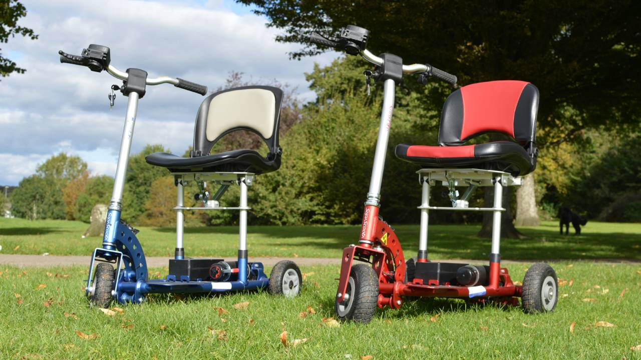 Supalite and Microlite SupaScoota lightweight mobility scooters side by side on grass in a park.