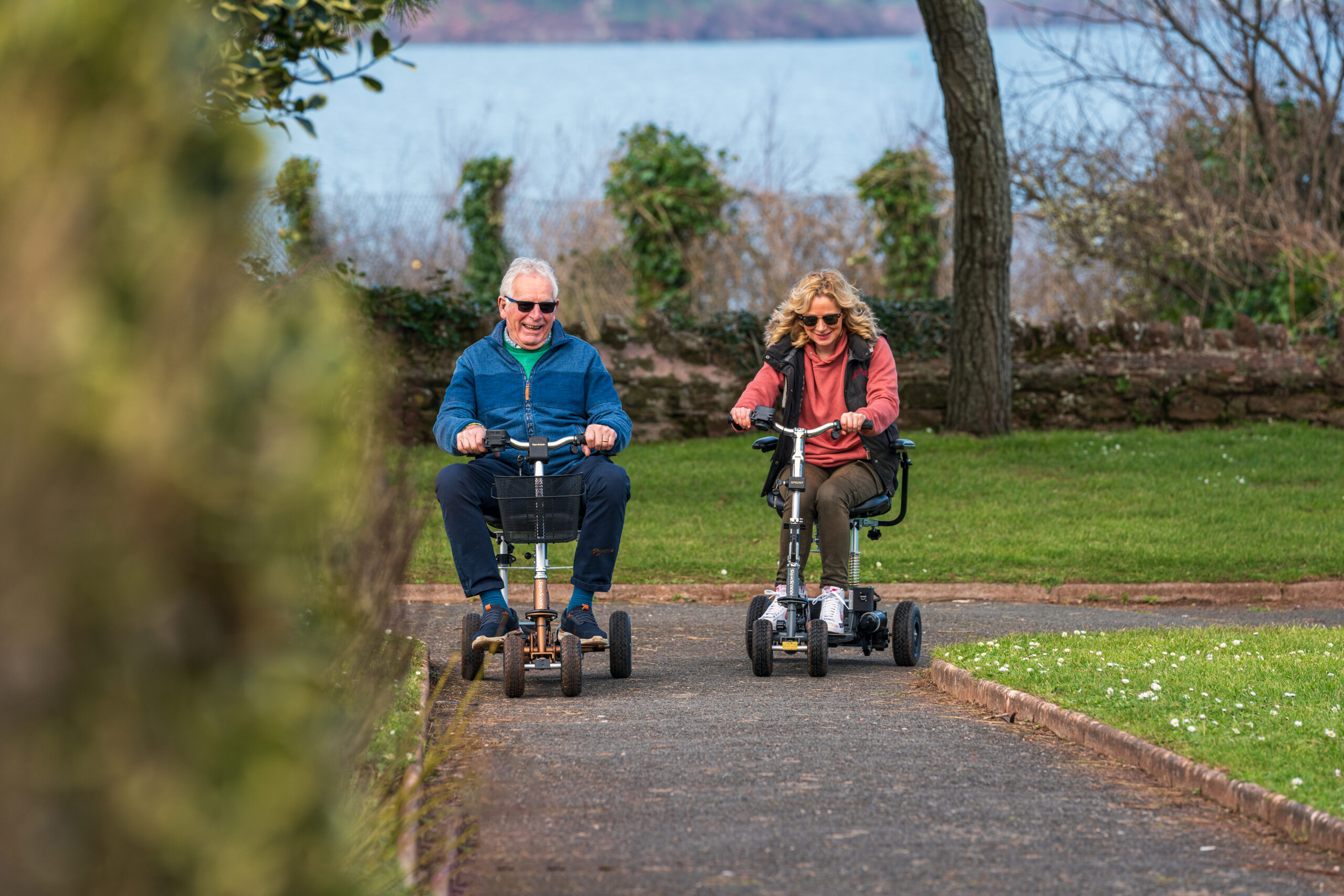 two-happy-people-using-mobility-scooter-hire-solutions